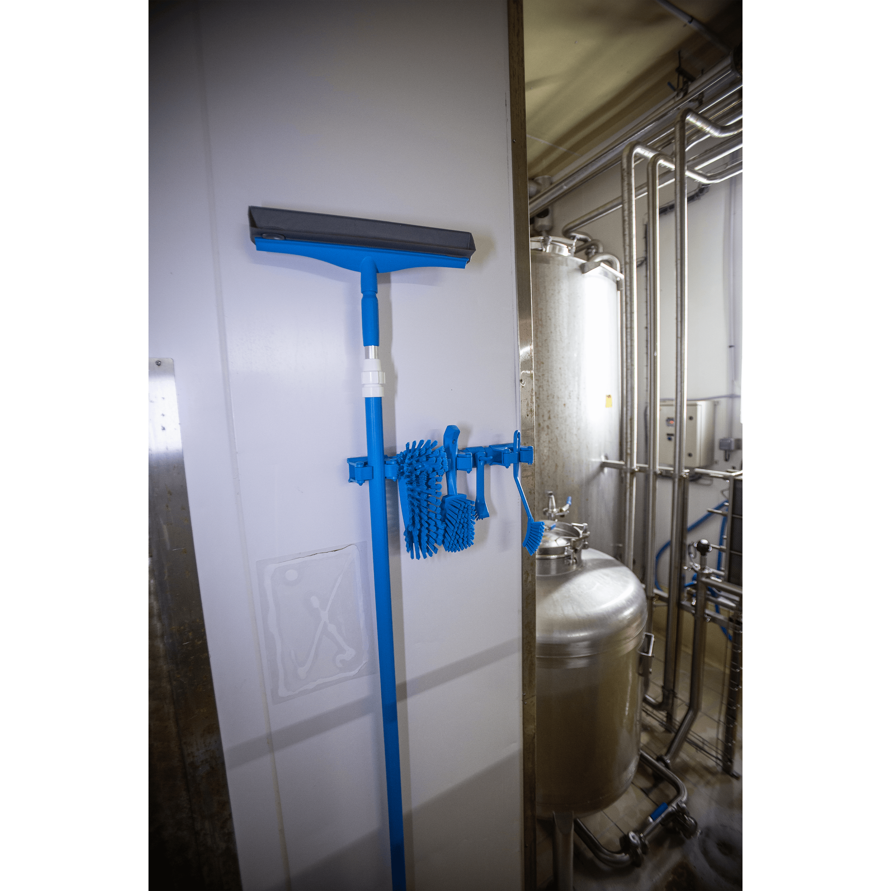 Blue squeegee and brushes hanging on wall.