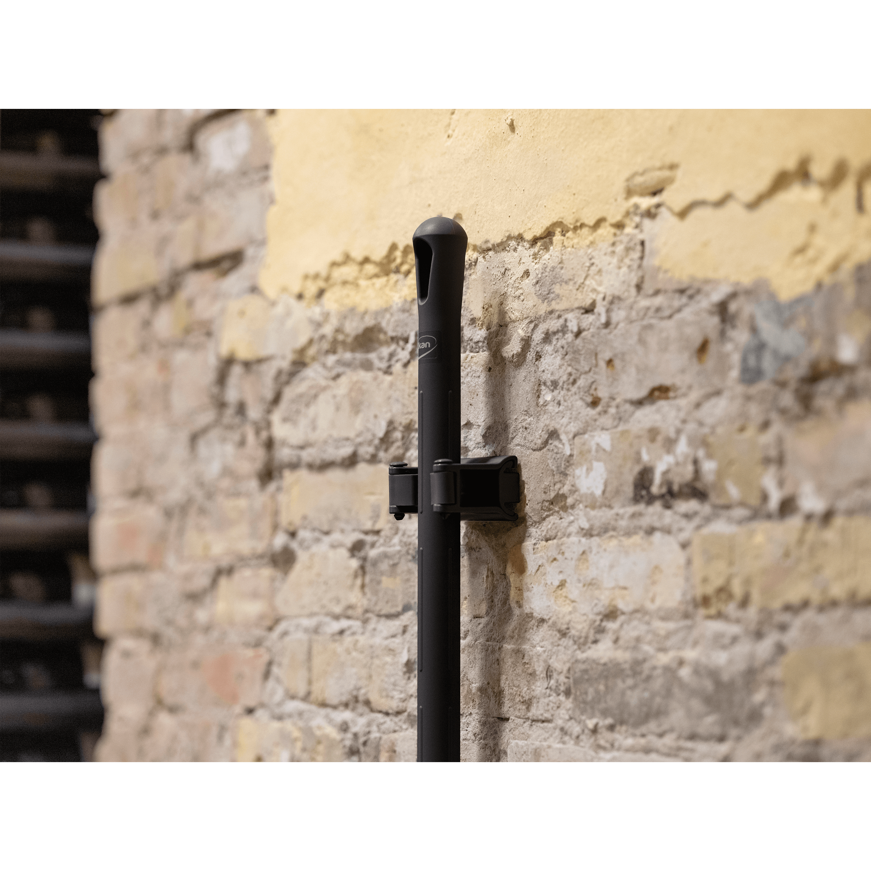 10132-3 Black broom handle mounted on brick wall.