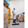 A worker sweeps the floor in a warehouse.