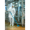 Worker cleaning factory floor with blue brush.