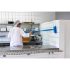 Person cleaning tiled kitchen wall with brush.