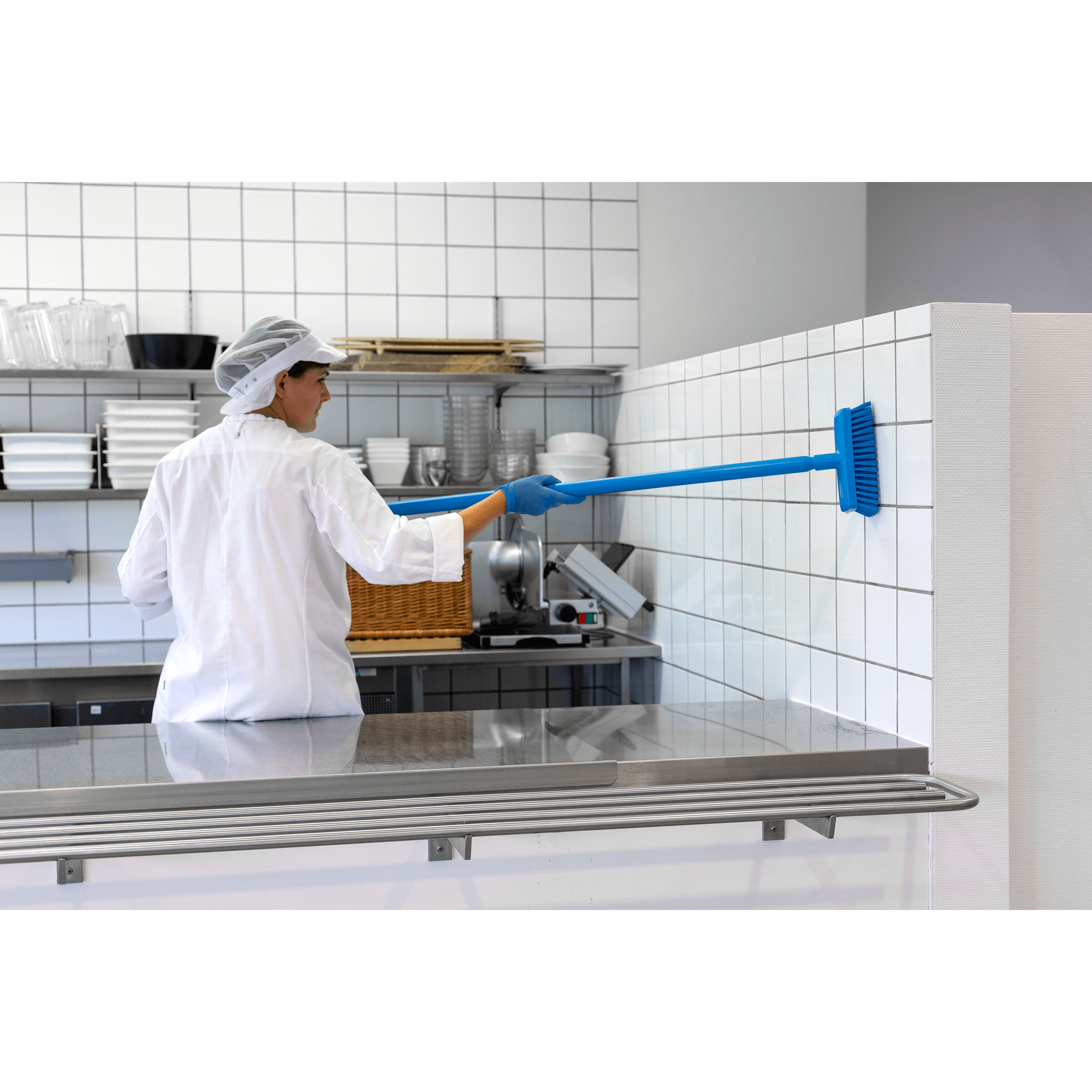 29609-4 Person cleaning tiled kitchen wall with brush.