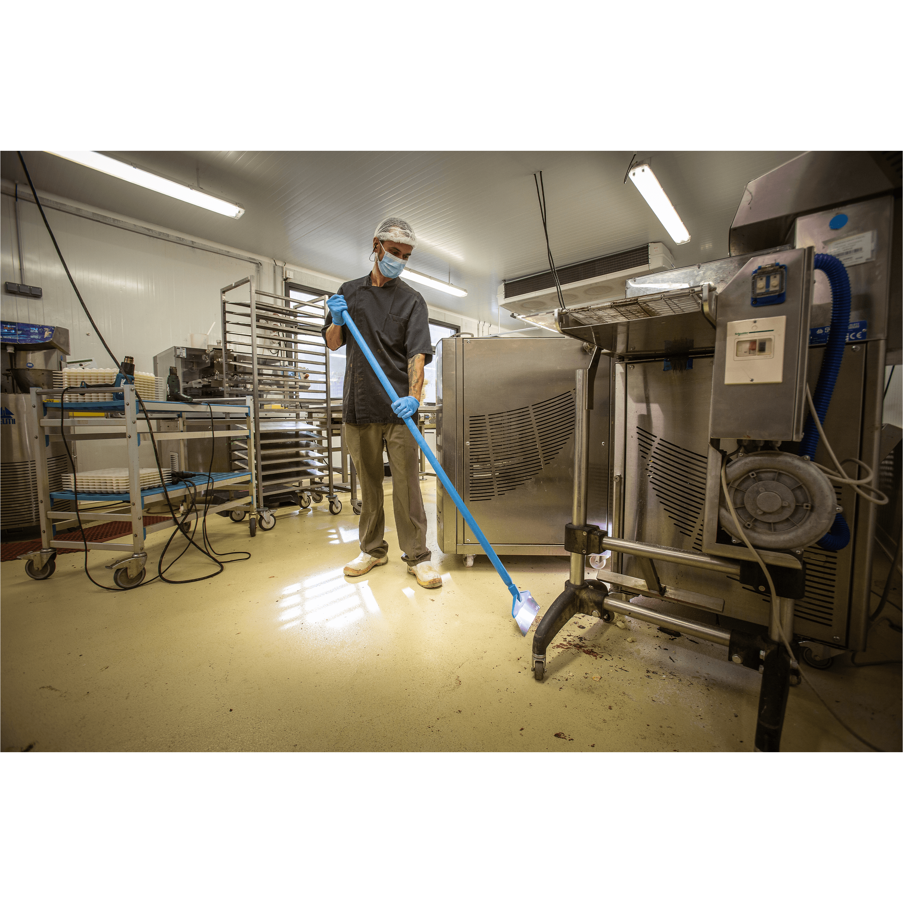 29622-4 Man sweeping floor in a factory.