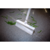 White broom cleaning green beans on floor.