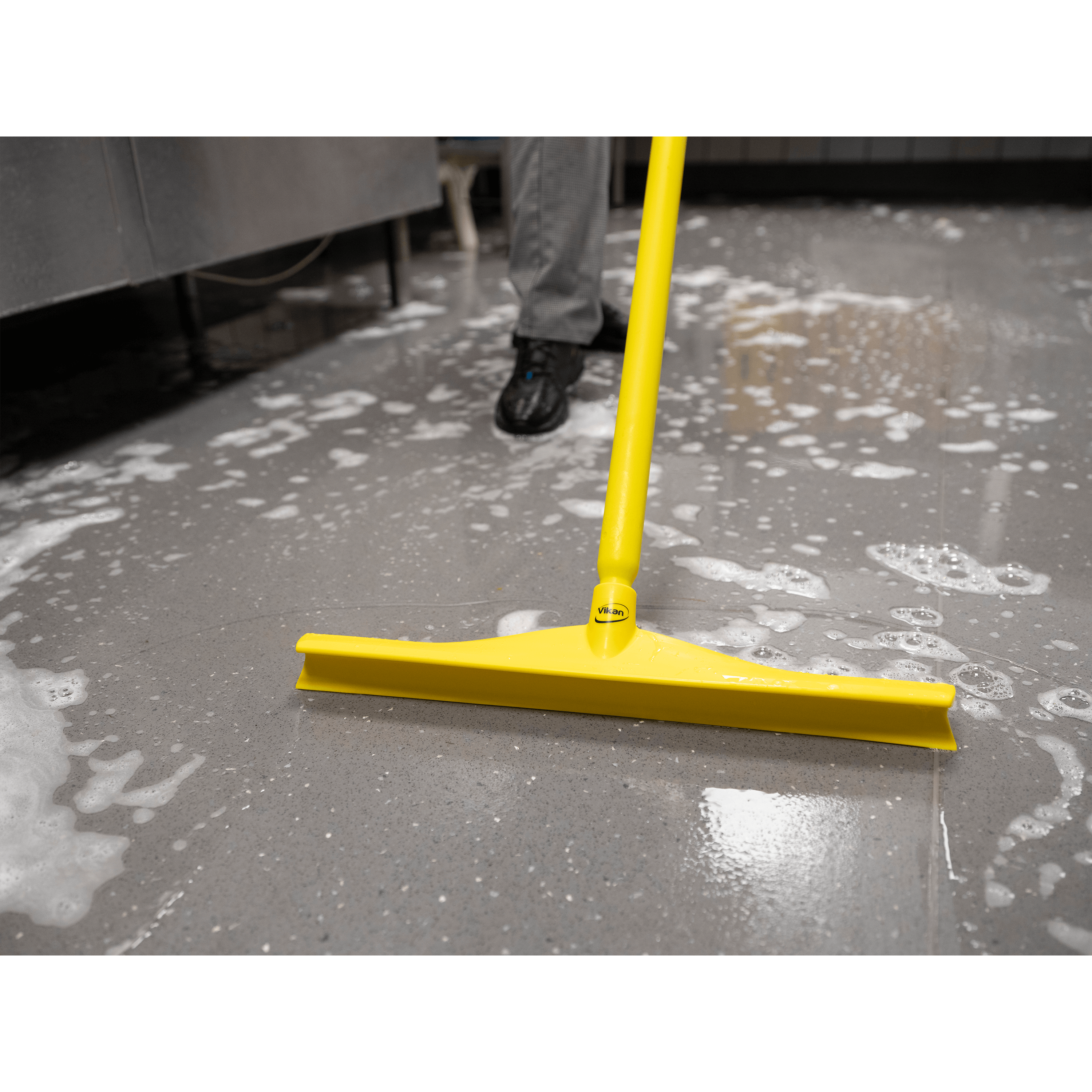 29626-3 Yellow squeegee on wet floor with soap suds.
