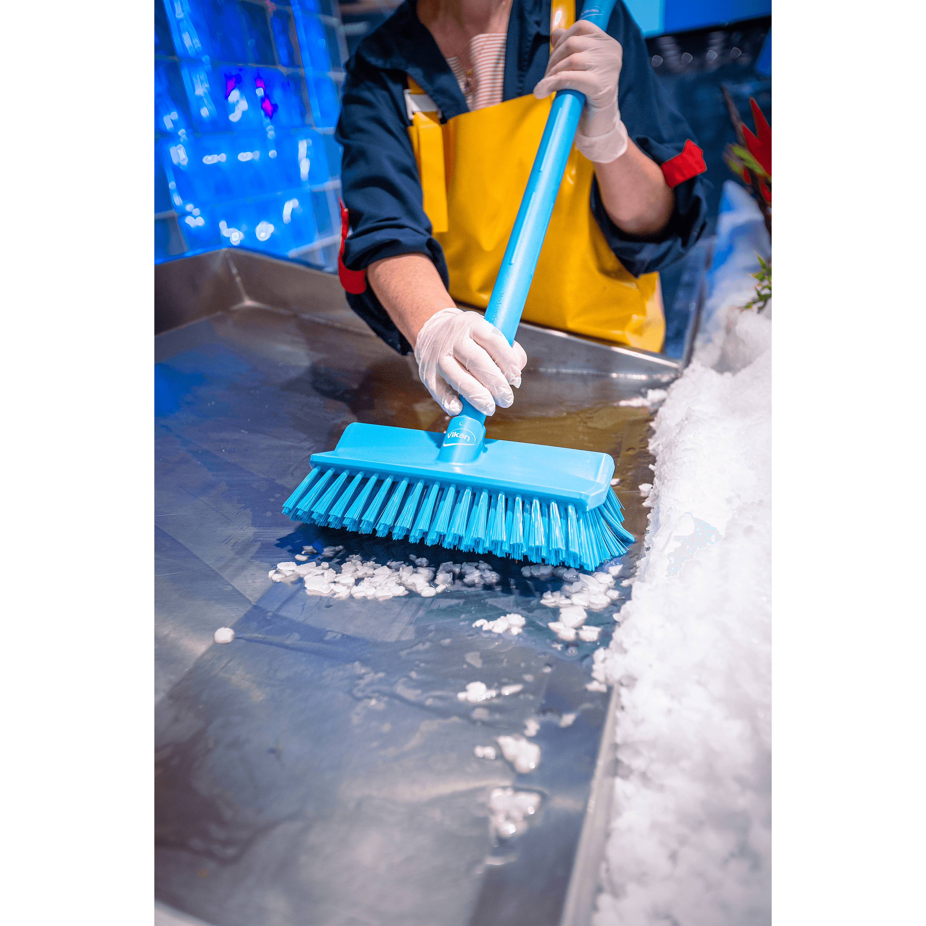 29665-3 Person cleaning ice with a blue brush.