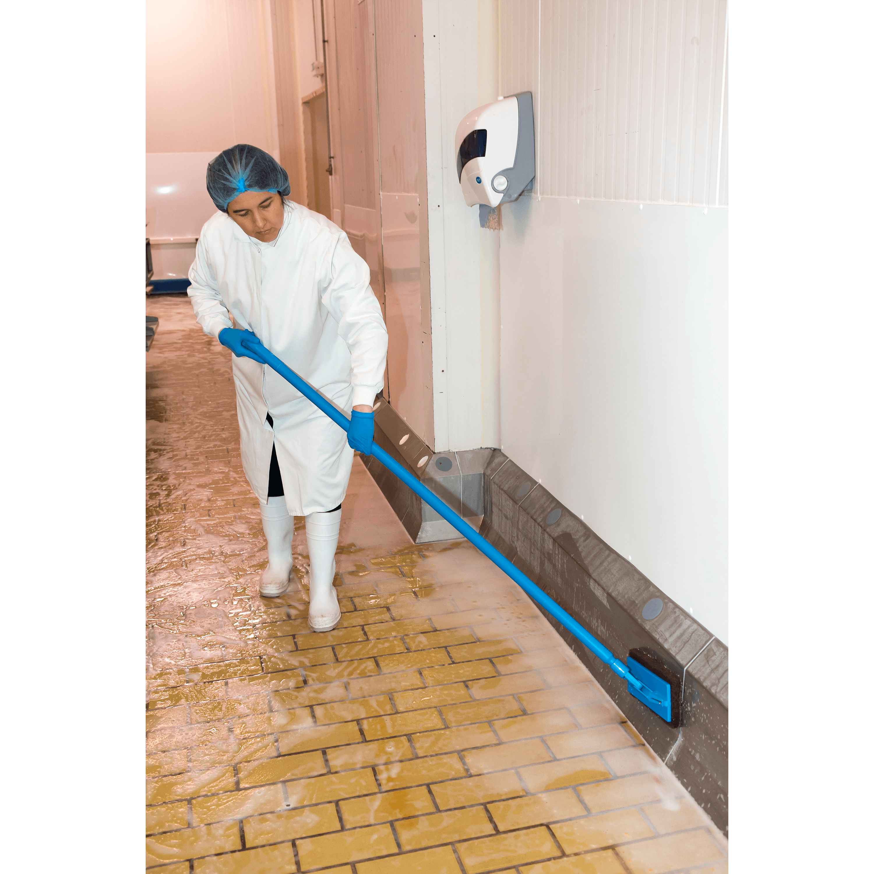 Woman cleaning industrial floor with mop.
