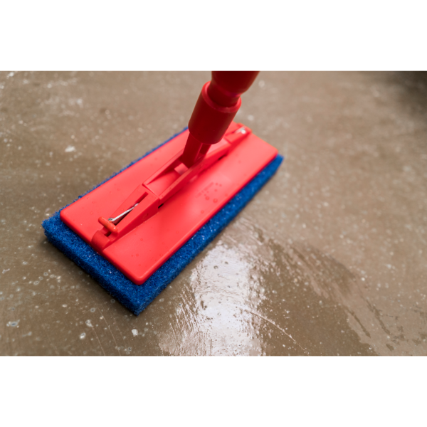 Red cleaning mop on wet floor.