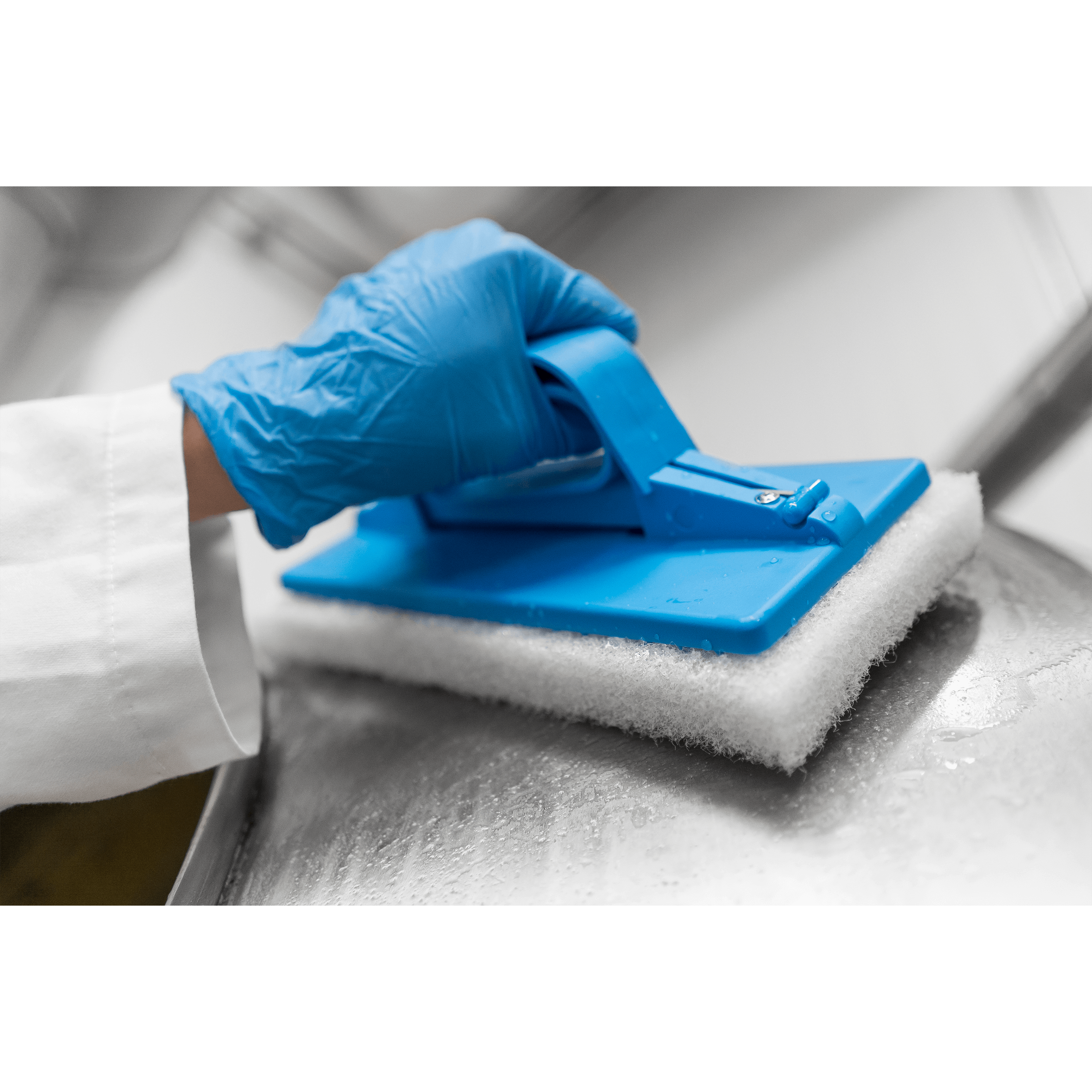 Here's a short alt tag for the image: Gloved hand cleaning surface with sponge.