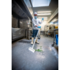 A chef sweeping green beans in a kitchen.