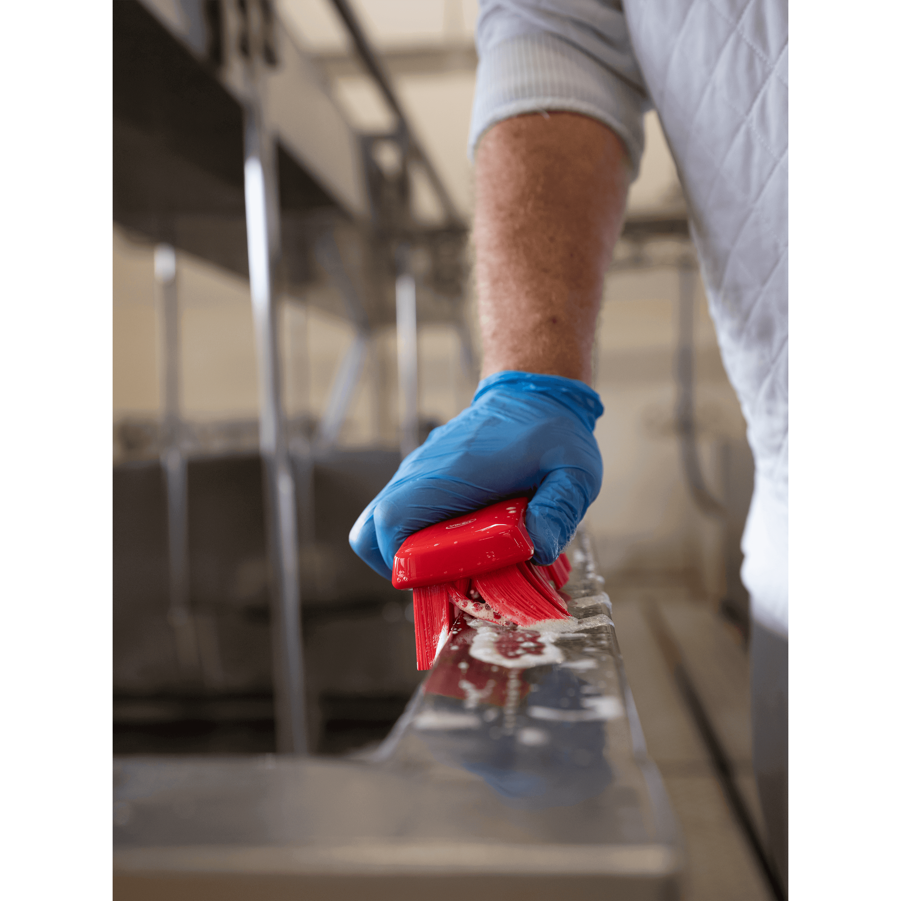 Person using a red cleaning brush.