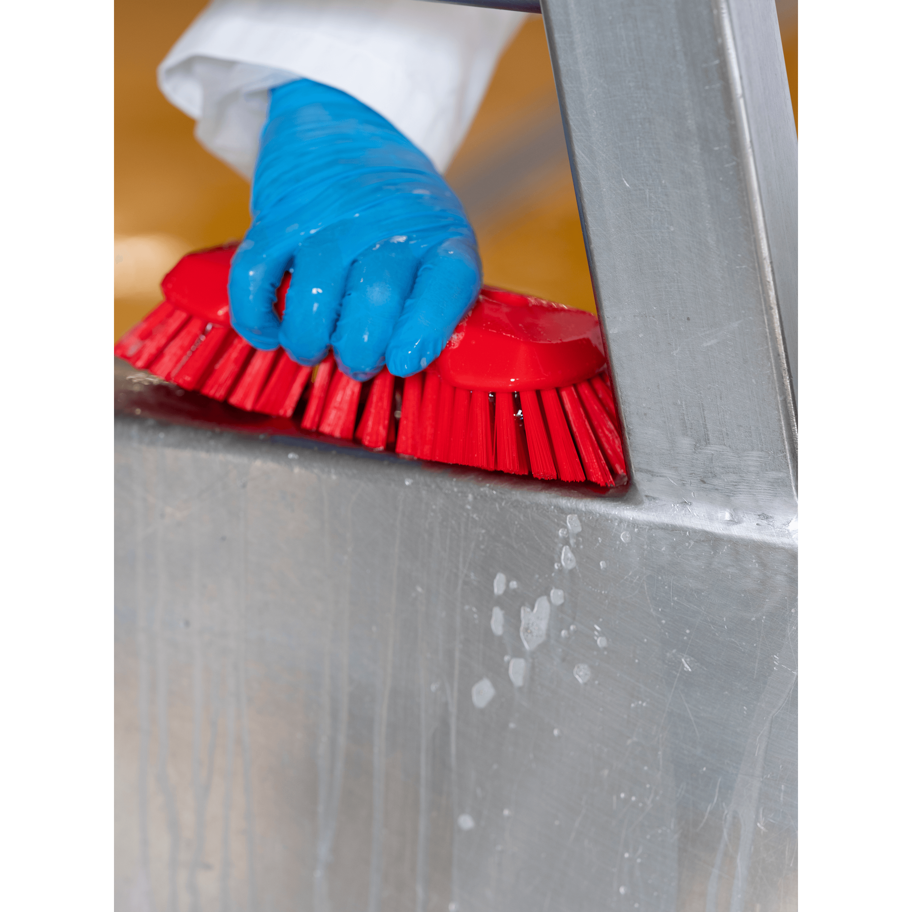 Hand cleaning a stainless steel surface.