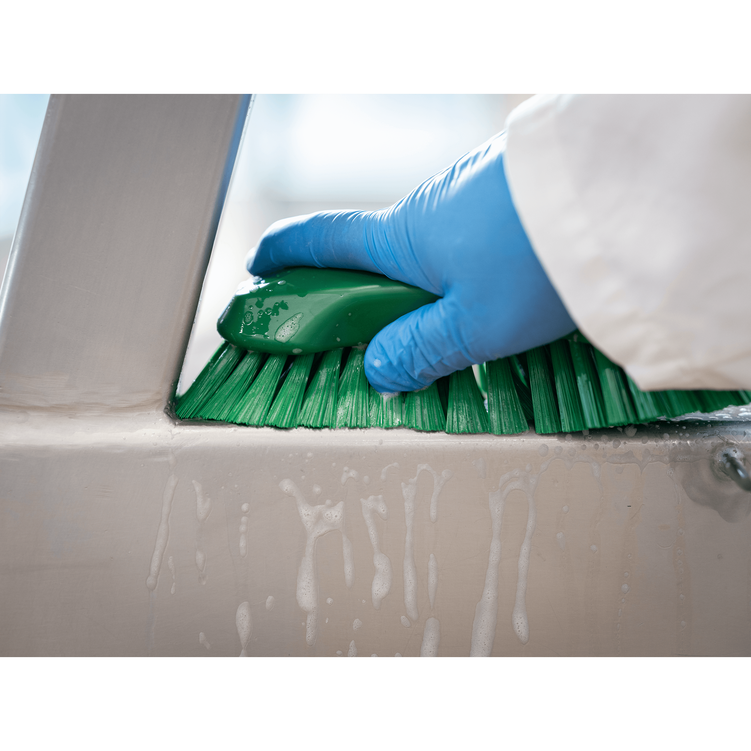 Person scrubbing a surface with a brush.