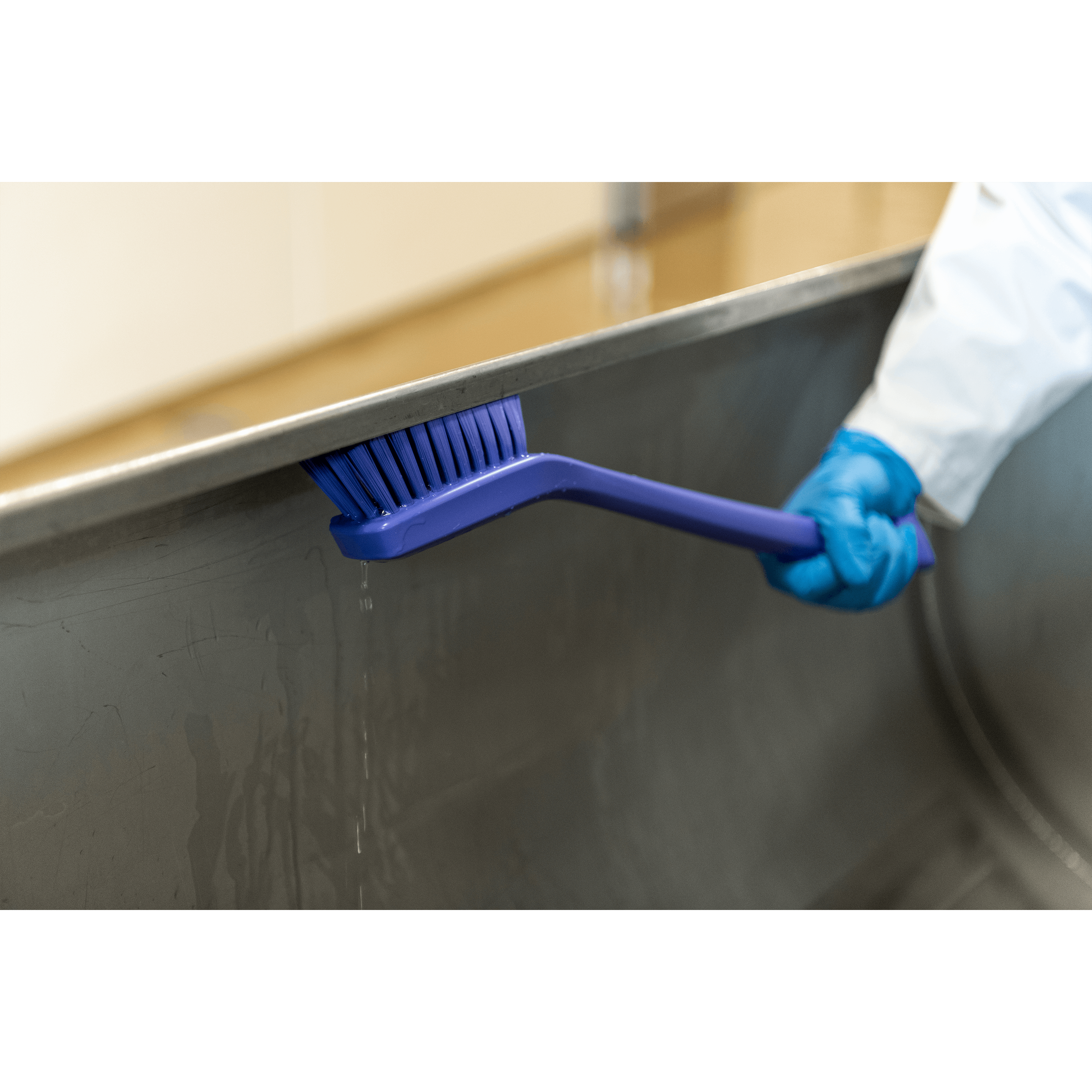 41855-3 Cleaning a surface with a purple brush.