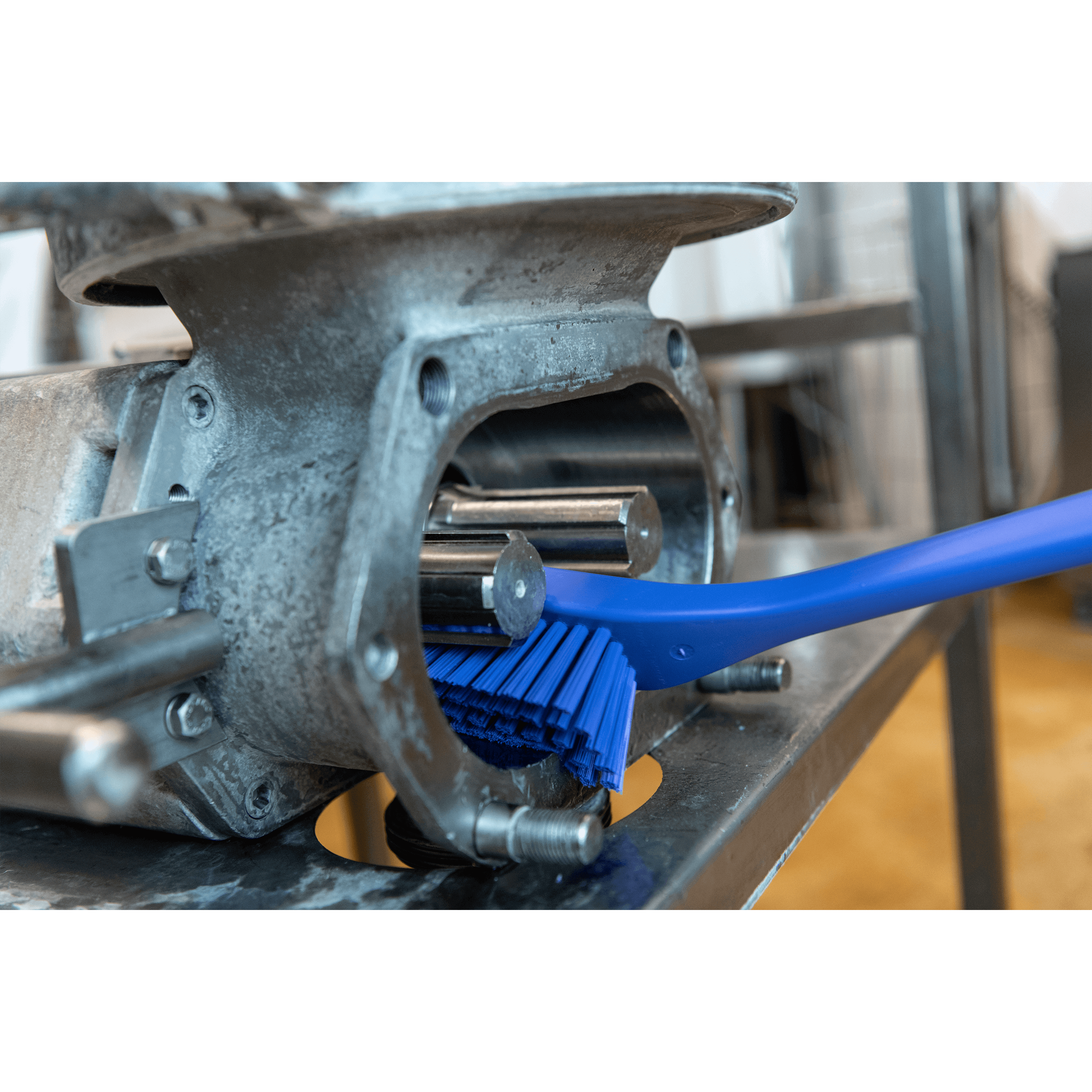 Blue brush inside a metallic machinery component.